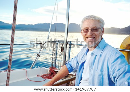 successful retired man sailing portrait at sunrise on boat