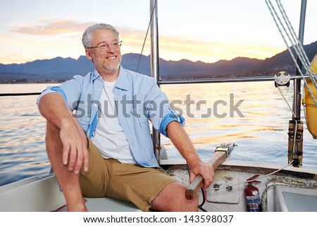 carefree happy sailing man portrait of mature retired man on ocean boat at sunrise