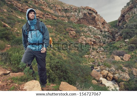 Adventure man hiking wilderness mountain with backpack, outdoor lifestyle survival vacation