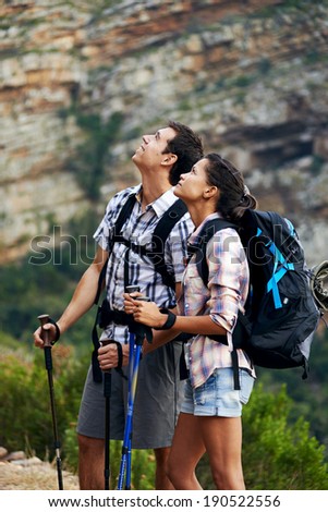 A young couple taking a break from hiking by looking up and admiring the view