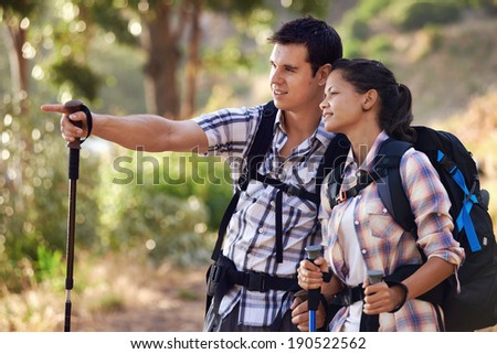 A man pointing something out to his girlfriend on the hiking trail