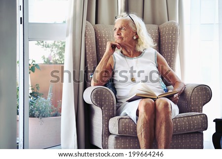 A senior woman sitting on her chair lost in thought