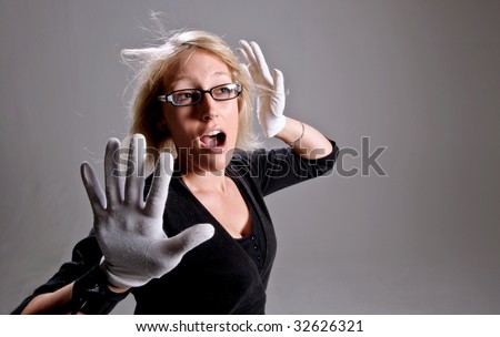 A girl is trapped in a box, she mimes her way around the imaginary walls in this studio shoot.