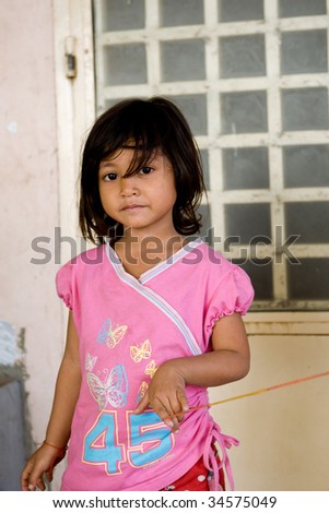 PHNOM PEHN, CAMBODIA - CIRCA JANUARY 2009: A young girl poses for a picture in Phnom Pehn, Cambodia Circa January 2009. Genocide attacks in 1975 - 1979 has caused many children to grow up in poverty.