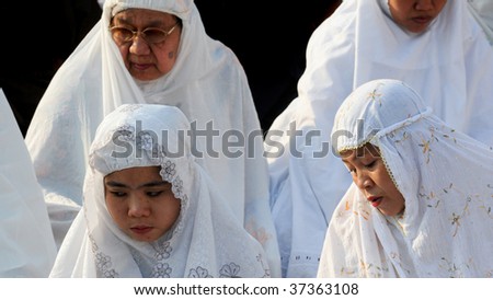 JAKARTA, INDONESIA - SEPTEMBER 20: Muslim woman praying outside a mosque in Jakarta on Hari Raya, the end of a month of fasting called Ramadan September 20, 2009 in Jakarta.