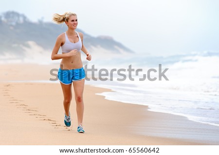 Young blond female runs along the beach
