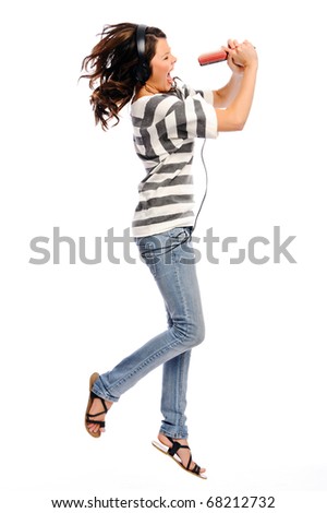 Attractive young woman jumps and pretend that she is a pop star