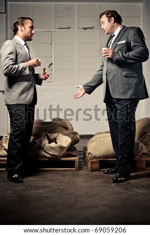 two businessmen discuss the coffee and drink espresso together
