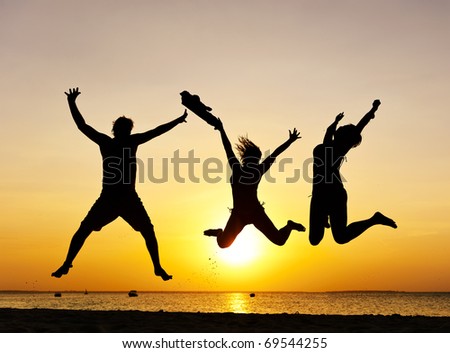 Happy jump during sunset or sunrise while on holiday at the beach.