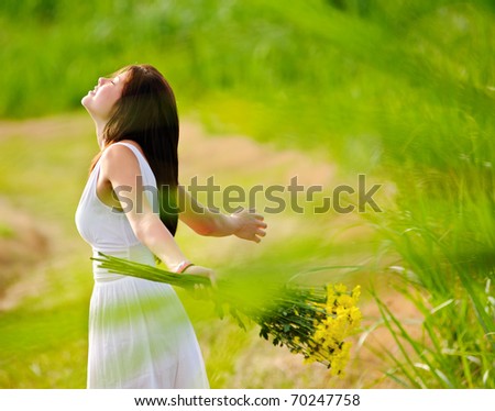 Carefree adorable girl with arms out in field. summer freedom andjoy concept.
