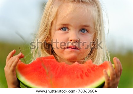 Young blonde girl wonders if she wants to continue eating this not so sweet watermelon