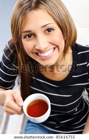 Young attractive woman is happy with her cup of tea, top down perspective