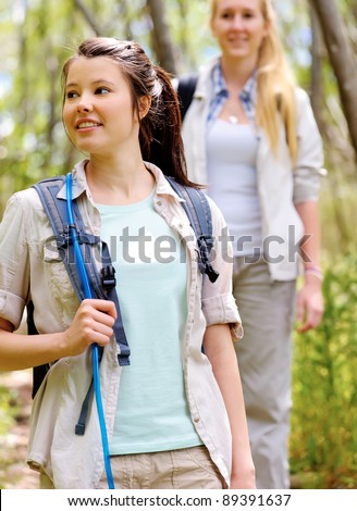 two beautiful attractive woman hiking outdoors in the woods. healthy active lifestyle concept
