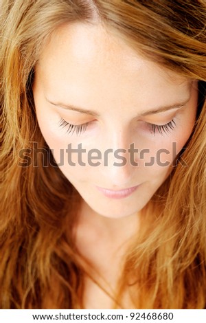 Close up portrait of a redhead caucasian woman looking down, with barely any make up - a top down perspective