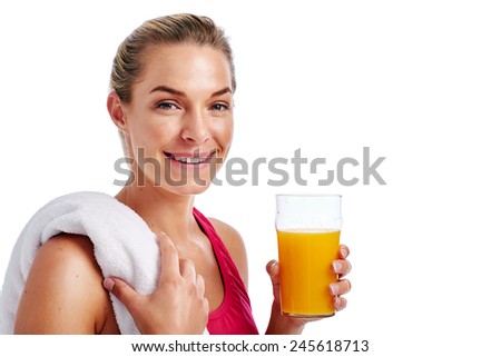 Woman getting ready for gym workout with towel and orange juice in studio