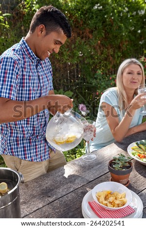 group of friends having outdoor garden dinner cocktail party
