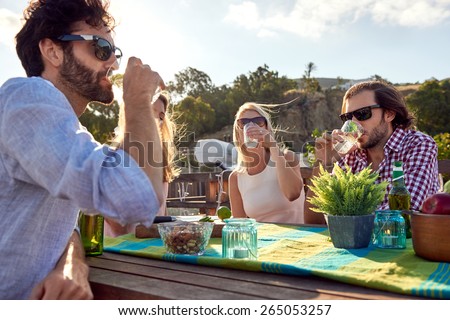 Group of friends sitting hanging out with drinks on the rooftop