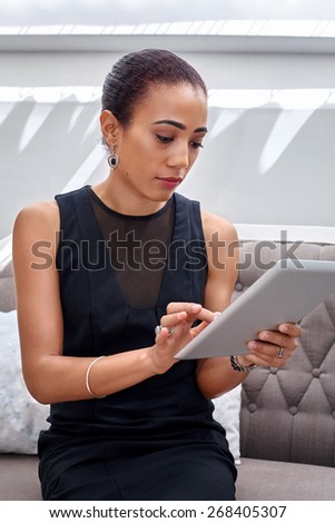 young professional businesswoman with tablet computer on sofa couch working wifi connection