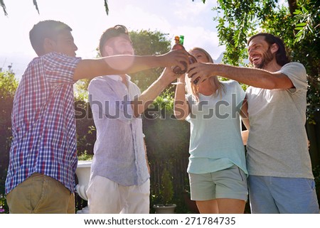 group of friends having outdoor garden party with alcoholic beer drinks