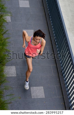 overhead view of active sporty woman training outdoors for marathon run in morning