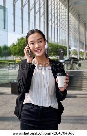 asian chinese businesswoman office worker communicating with mobile phone on coffee break
