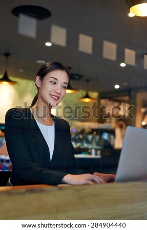 young asian chinese business woman using cafe wifi connection for laptop computer work