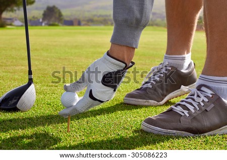 golf man placing ball for tee shot on vacation