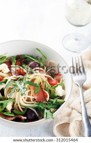 spaghetti pasta with green salad rocket, asparagus, ham and glass of white wine