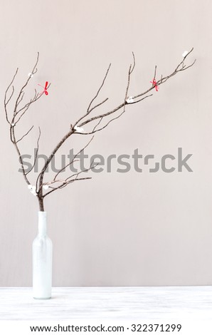 Table top decoration, vase with wooden branch twig with red ribbons, simple elegant rustic holiday festive christmas background