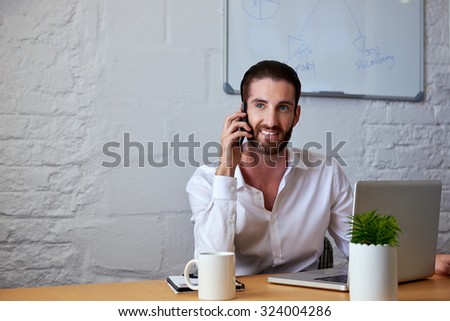 professional business man talking on mobile cell phone to clients in office with laptop computer