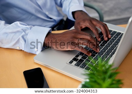 man typing on laptop computer at office work desk