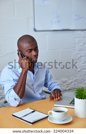 professional african black man talking on mobile cell phone to clients in office