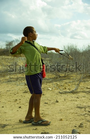 MACAU, RN, BRAZIL - JANUARY 13 : Brazilian unidentified child during birds hunt on January 13, 2014. With a sling he try to get his dinner complement before the sunset.