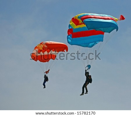 Two Parachutes in blue sky.