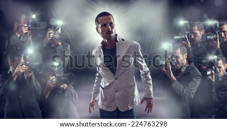 Portrait of attractive male vip celebrity posing in front of photographers paparazzi