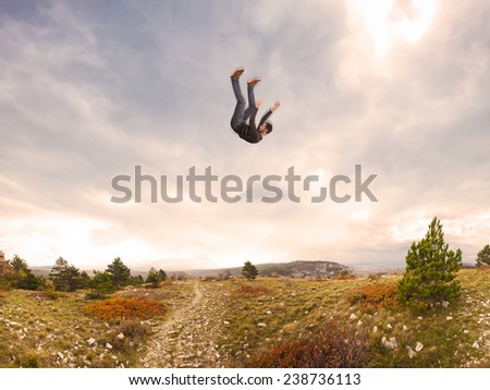man falling down from the sky in autumnal landscape