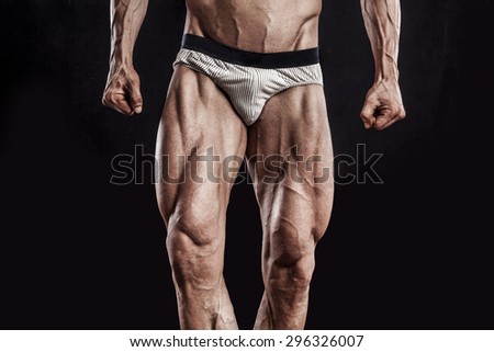 muscle man legs on black background, bodybuilding athlete portrait