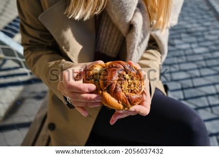 Woman's Hand Holding Delicious Swedish Buns, Kanelbullar. Baking close-up. A sweet snack outdoors. Traditional Swedish pastries ストックフォト © 