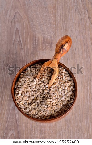 Pearl barley in wooden plate with sovochkom