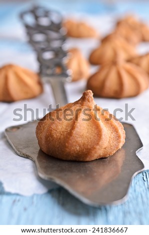 Small cone-shaped cookies brown lies on the blade for cake