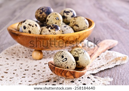 Quail spotted eggs in a wooden spoon