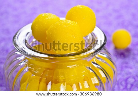 Yellow candy in sugar, round shape. Selective focus.