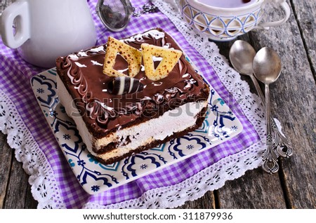 Chocolate cake with a shiny glaze and chocolate decorations. Selective focus. Back-lighting.