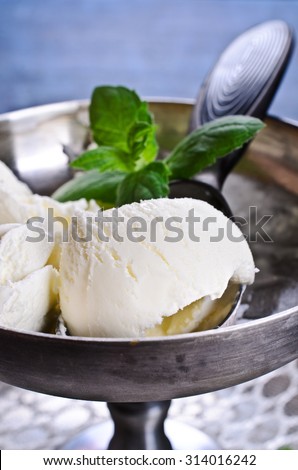 White ice cream with a mint leaf in metal ware. Selective focus