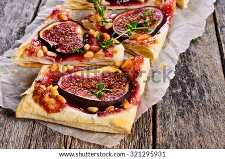 Cake with figs, jam and nuts on parchment paper