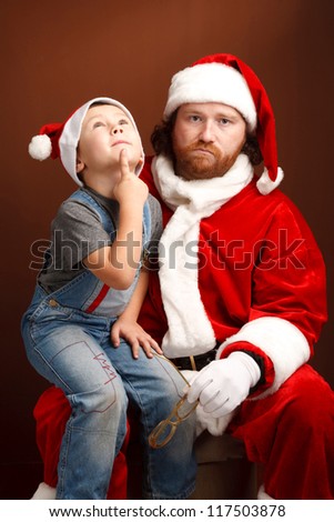 Boy is  sitting on Santas knee and thinking about his future present.  Man,dressed in Santa costume looks tired and unhappy