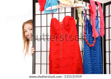 Young beautiful woman looks out of the folding screen ,lots of clothes and underwear hang on it