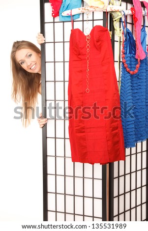Young beautiful woman looks out of the folding screen ,lots of clothes and underwear hang on it