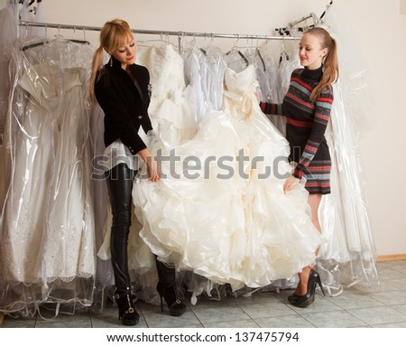 Two girlfriends   looking for dresses for wedding