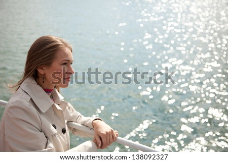 Young beautiful woman standing near water line .Copyspace
